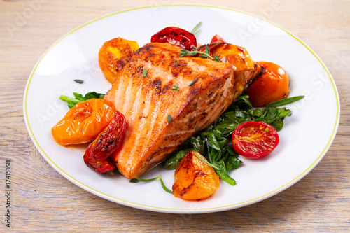 Fotografie Salmon fillet with spinach, tomatoes and herbs, horizontal