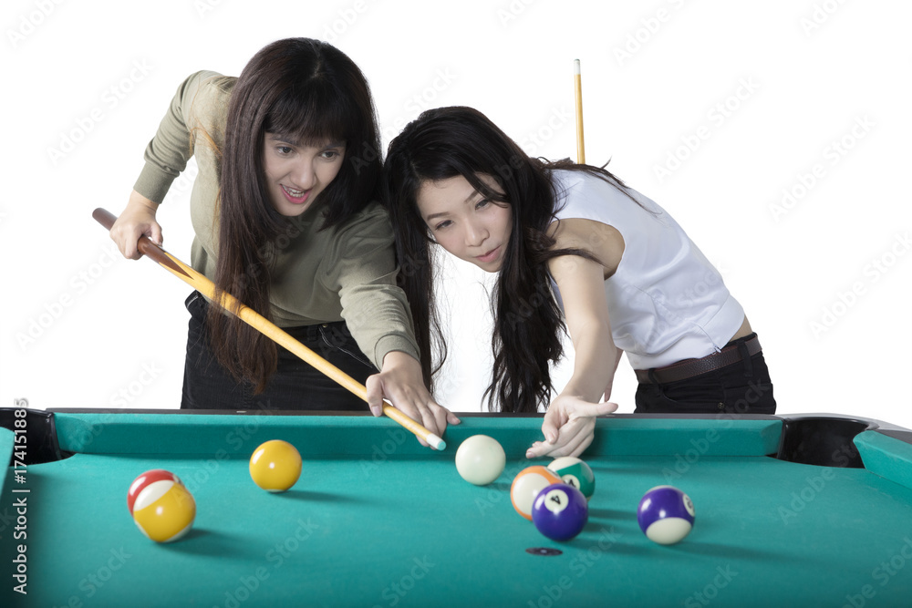 Fototapeta premium Two multiethnic girls playing billiards