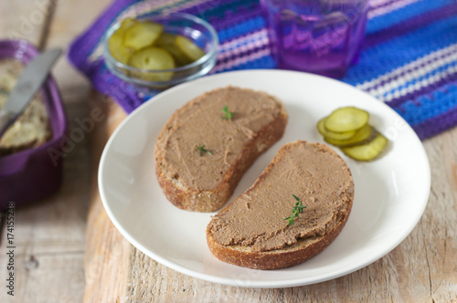 Homemade liver pate with bread and canned cucumber. Rustic style, selective focus.