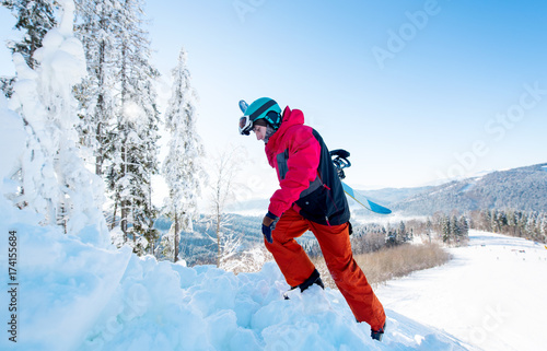 Full length shot of a freerider snowboarder carrying his snowboard, climbing up to the mountain copyspace active sports lifestyle recreation winter seasonal people