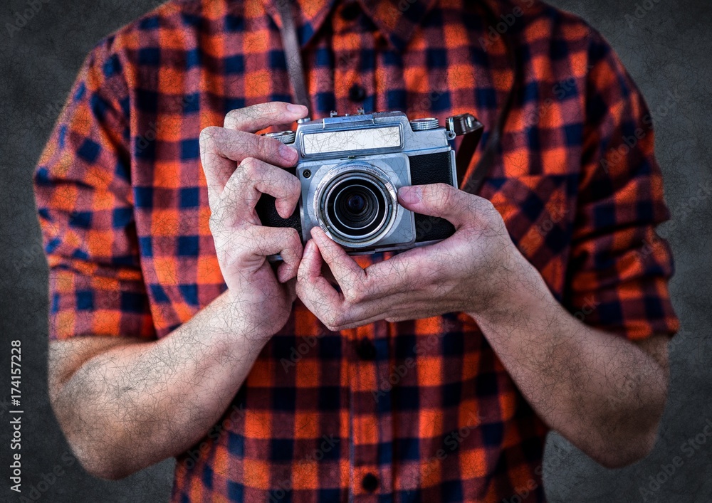 Millennial man mid section with camera against grey background Millennial man mid section with camera against grey background