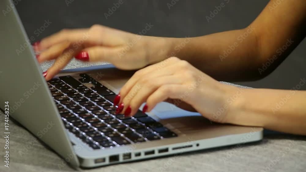 Businesswoman working on notebook laptop computer in the office. Detail shot of attractive woman fingers with red nice manicure. Businesswoman working on notebook laptop computer in the office. Detail shot of attractive woman fingers with red nice manicure.