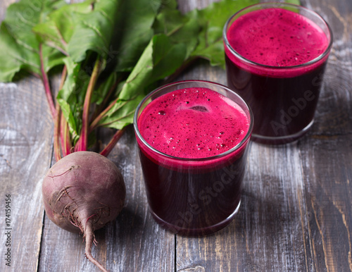Fresh beet juice in glasses on a wooden background, selective focus. Healthy detox diet