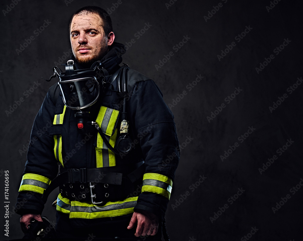 Studio portrait of a male dressed in a firefighter uniform. Studio portrait of a male dressed in a firefighter uniform.