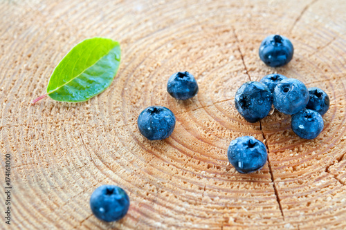 Blueberries are scattered on a tree stump, decorated sheet.