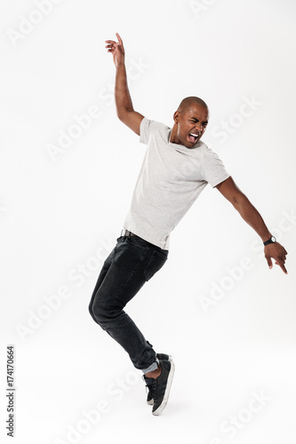 Emotional screaming young african man dancing isolated