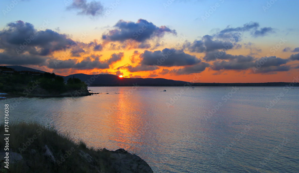 Sunset with clouds over the sea bay with hilly banks. Bulgaria, Sozopol.