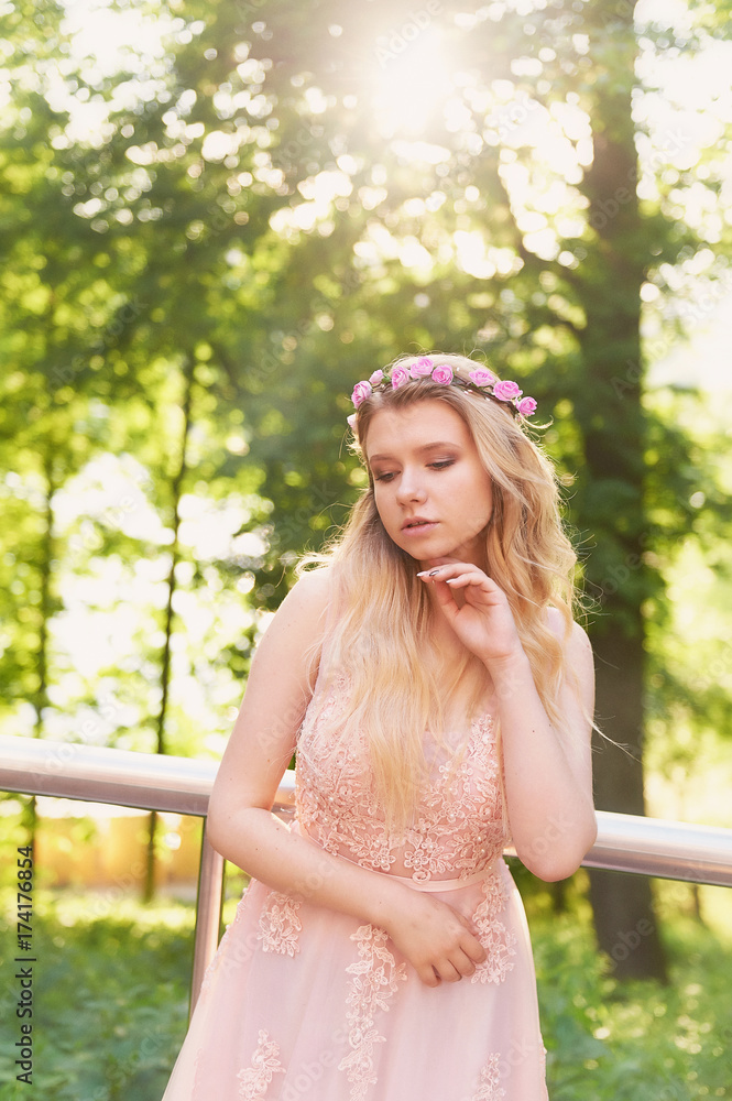 Naklejka premium Silhouette swirling in the setting sun in the beautiful woods of the bride in the peach dress with lace. Blonde with a good figure.The feeling of happiness and serenity