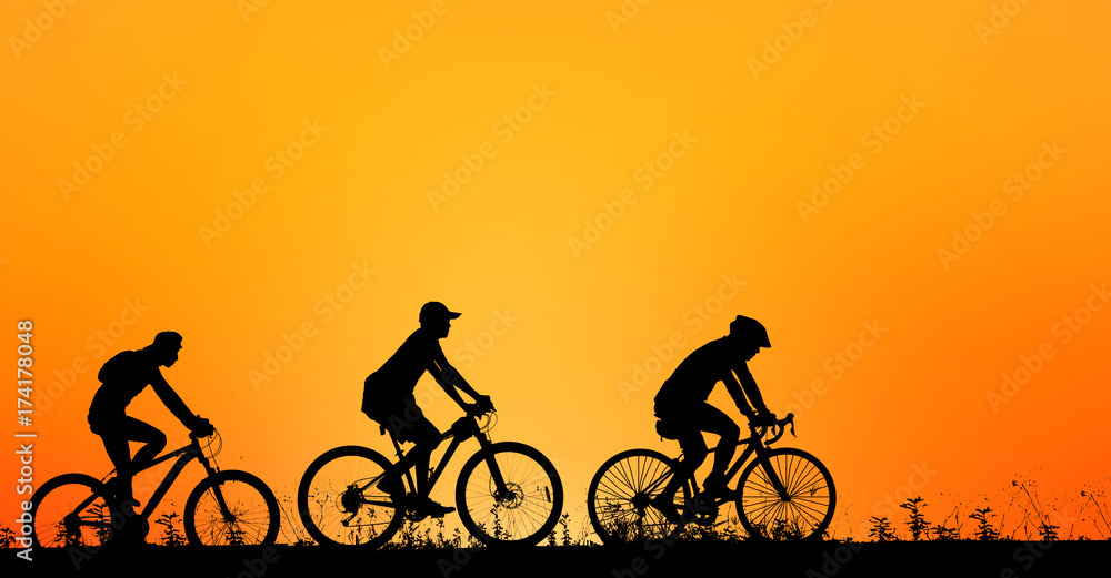 Obraz premium Silhouette man and bike relaxing on sunrise background