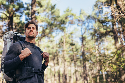 Man walking in forest wearing a backpack