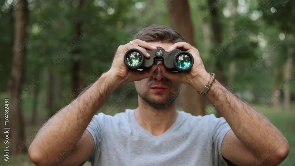 A young man looks through binoculars. A young man looks through binoculars.