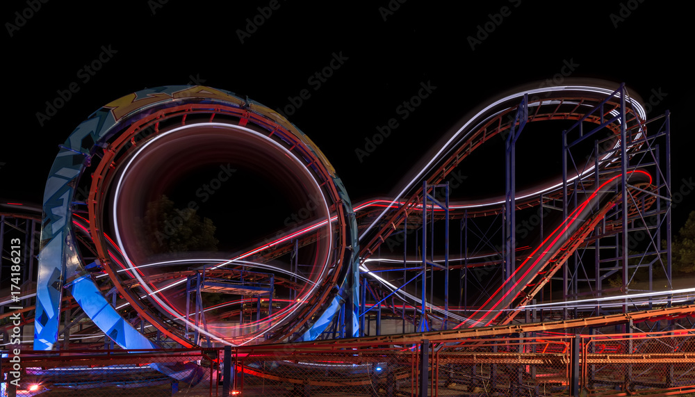  Attraction in the park. Roller coaster in motion at night. A long exposure photo