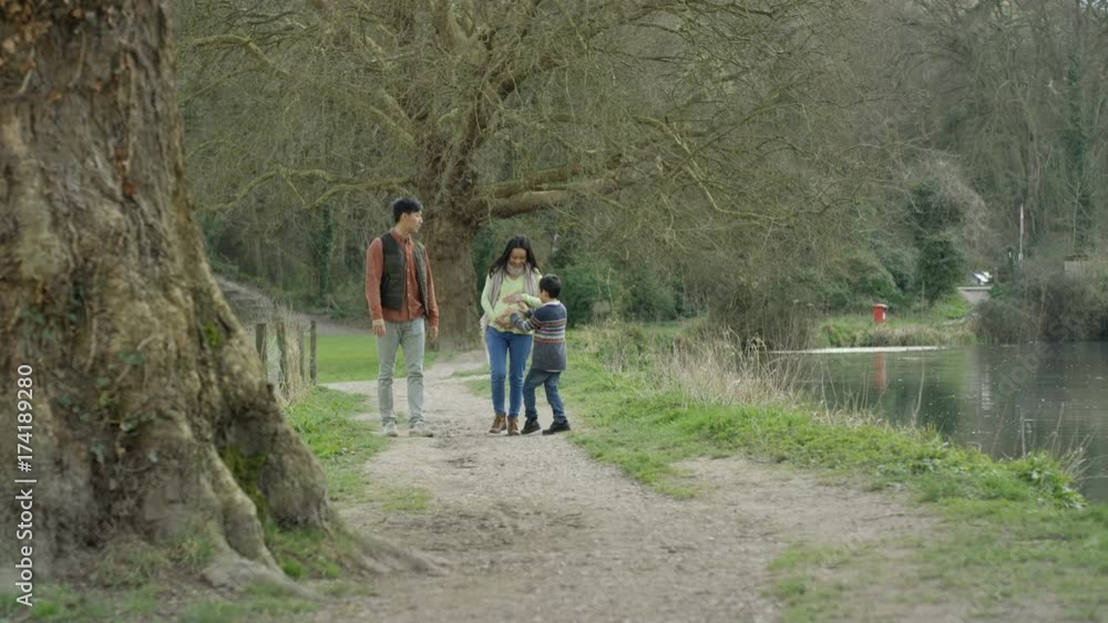 Happy family walking in the country, parents expecting baby with little boy Happy family walking in the country, parents expecting baby with little boy