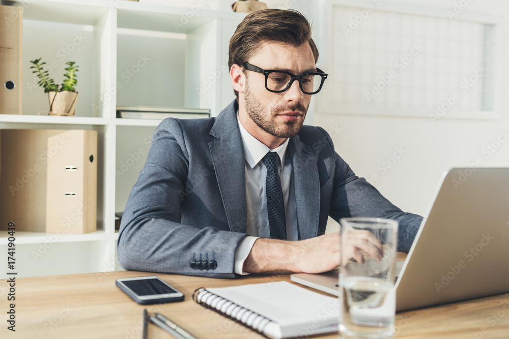 businessman in office working on laptop businessman in office working on laptop