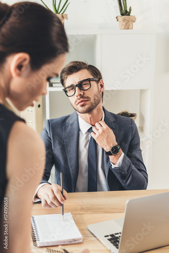 Businessman looking at beautiful secretery photo