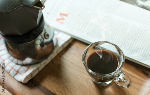 Hot Coffee in Espresso Cup with Magazine on the Table