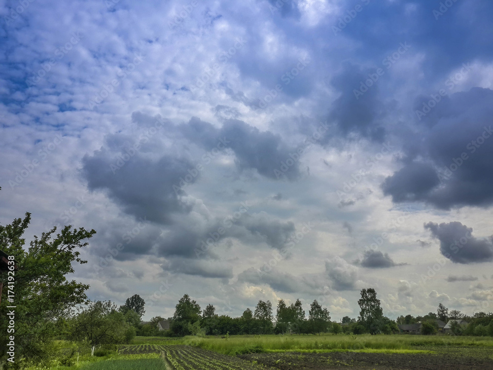 Beautiful thunderstorm clouds in dusky sky and countryside landscape