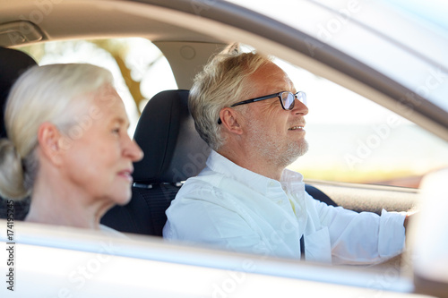 happy senior couple driving in car