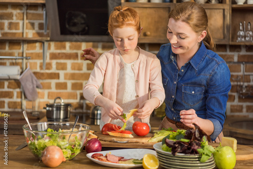 daughter and mother making salad