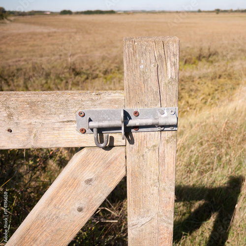 close up of metal lock on wooden country gate