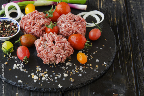 raw minced meat, vegetables with salt and spices, selective focus