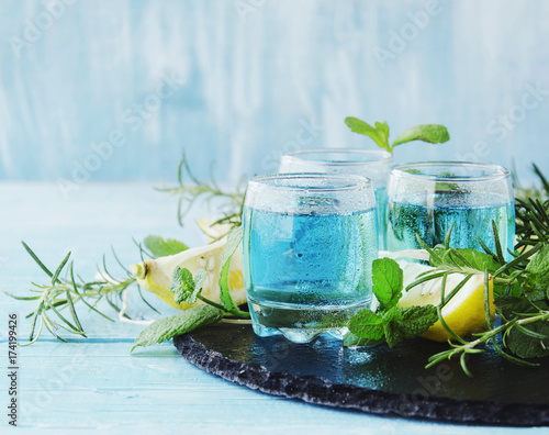 Foto Blue curacao liqueur or sambuca with lemon