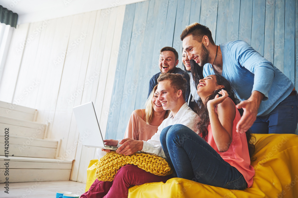 Obraz premium Group of creative young Friends Hanging Social Media Concept. People Together Discussing Creative Project During Work Process, play games or watch video film