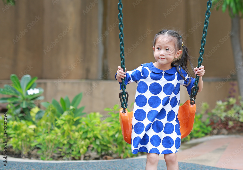 Asian little enjoy playing swing in the playground. Asian little enjoy playing swing in the playground.