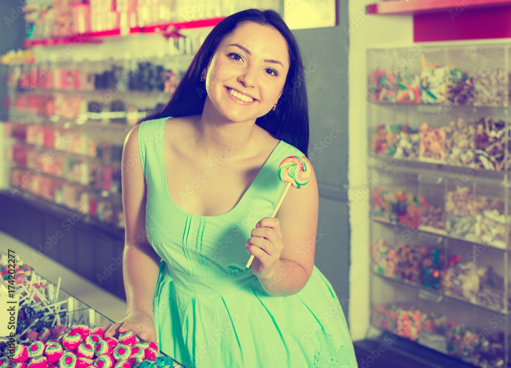 young sexy girl posing in the store with lolly