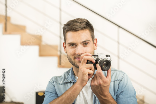 Man at home using vintage reflex camera