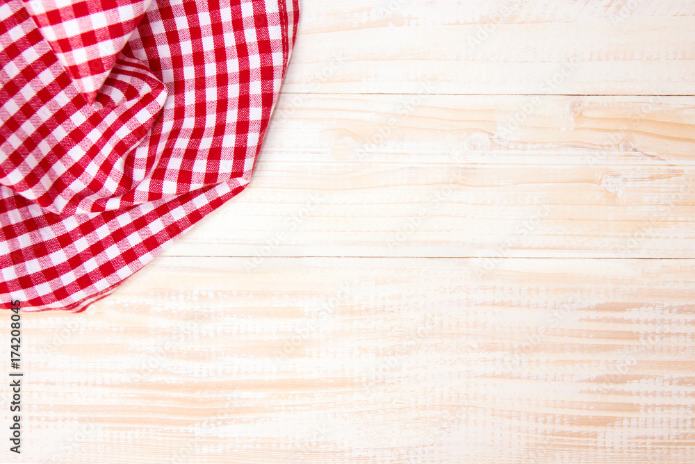 Obraz premium The checkered tablecloth on wooden table.