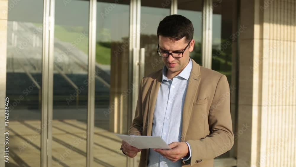 Manager tears documents against the background of the office building. Businessman tearing documents. Manager tears documents against the background of the office building. Businessman tearing documents.