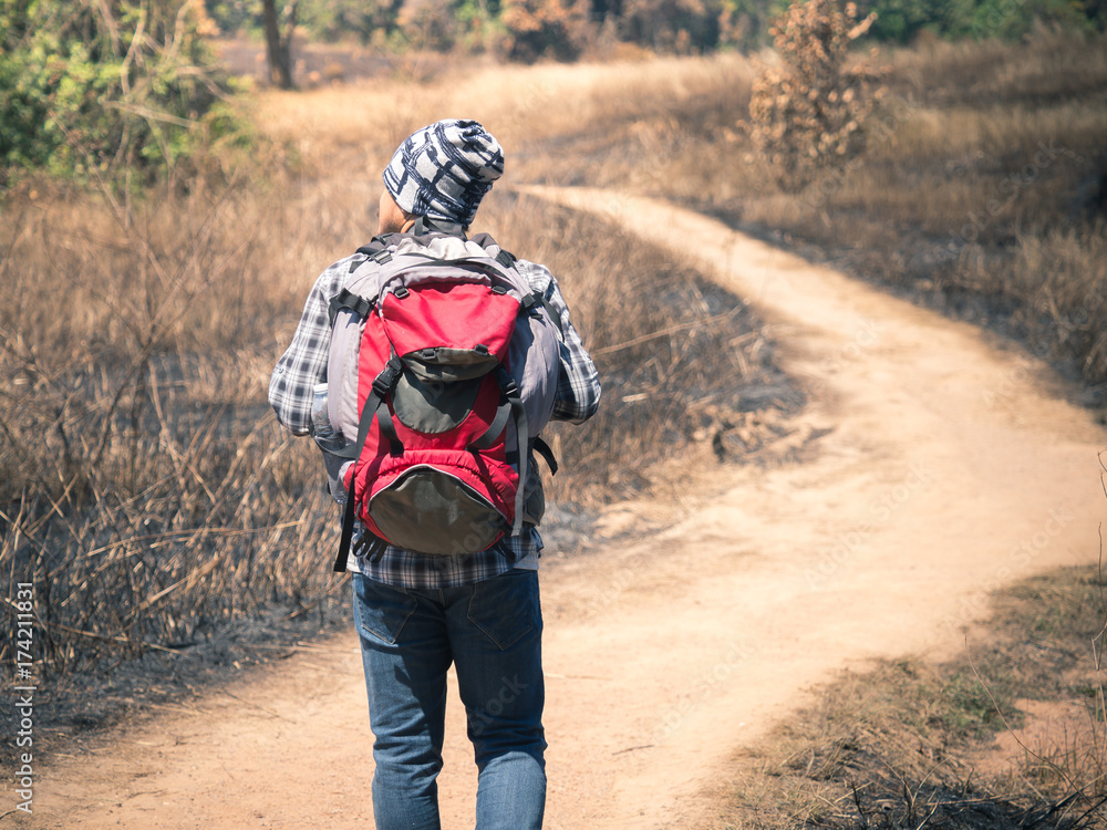 Young man hipster walking on mountain during traveling/trekking/hiking/camping, freedom lifestyle, backpacking leisure outdoor on holiday/vacation and adventure concept