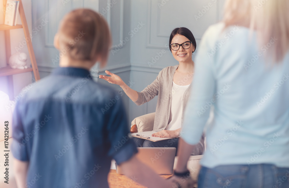 Obraz premium Positive school psychologist welcoming teen boy and his mother