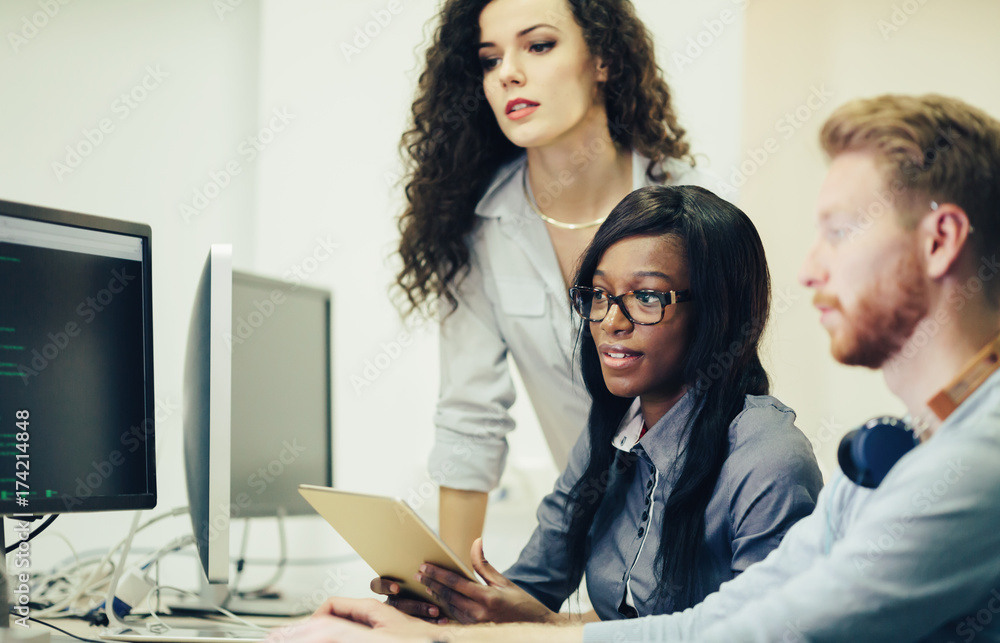 Programmers cooperating at information technology company Programmers cooperating at information technology company