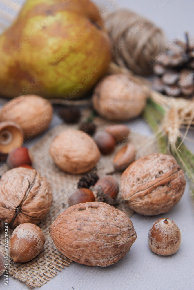 Autumn composition with nuts, pears and dry leaves on rustic background Autumn composition with nuts, pears and dry leaves on rustic background