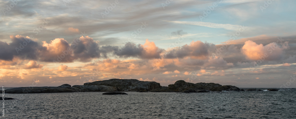 Obraz premium Sunrise with pink sky and clouds over the ocean and archipelago of Faerder National Park, Norway, panorama