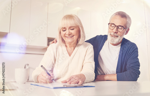 Cheerful old couple signing insurance contract