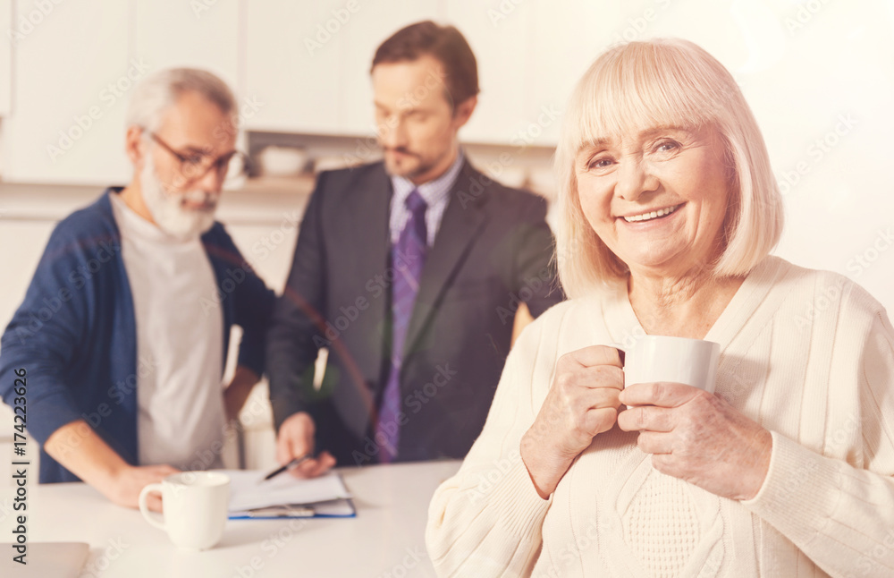 Cheerful retired woman drinking tea Cheerful retired woman drinking tea