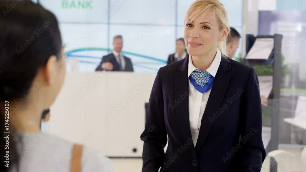 Customer with internet banking screen on phone talking to financial adviser Customer with internet banking screen on phone talking to financial adviser