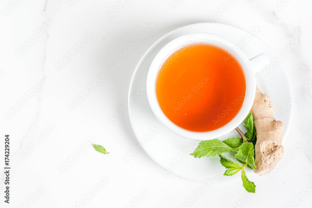 Cup of ginger tea with lemon,fresh mint and honey, on white marble table, copy space top view Cup of ginger tea with lemon,fresh mint and honey, on white marble table, copy space top view