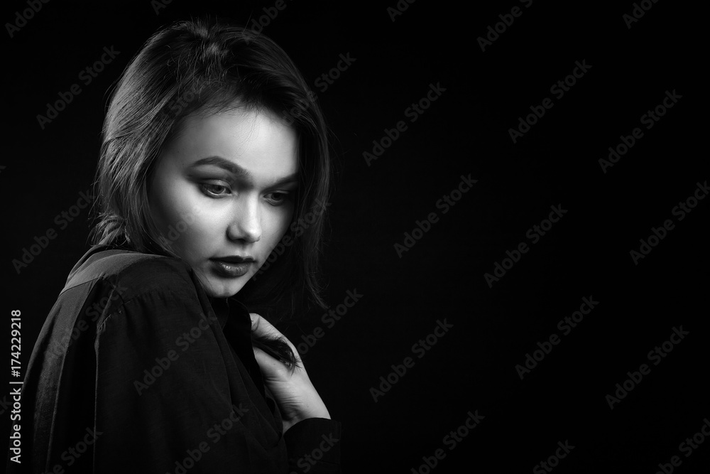 beautiful young sad woman in blouse at black background with copy space, monochrome beautiful young sad woman in blouse at black background with copy space, monochrome