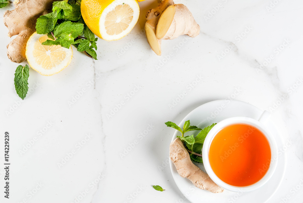 Cup of ginger tea with lemon,fresh mint and honey, on white marble table, copy space top view Cup of ginger tea with lemon,fresh mint and honey, on white marble table, copy space top view
