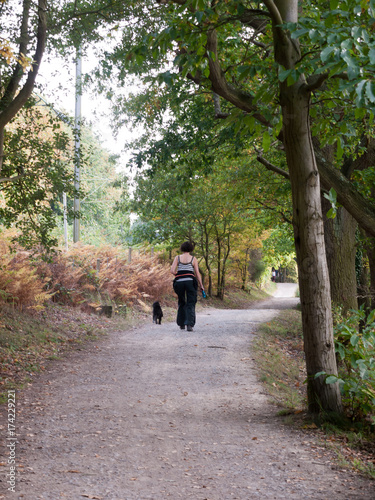 woman walking dog down country path ramble