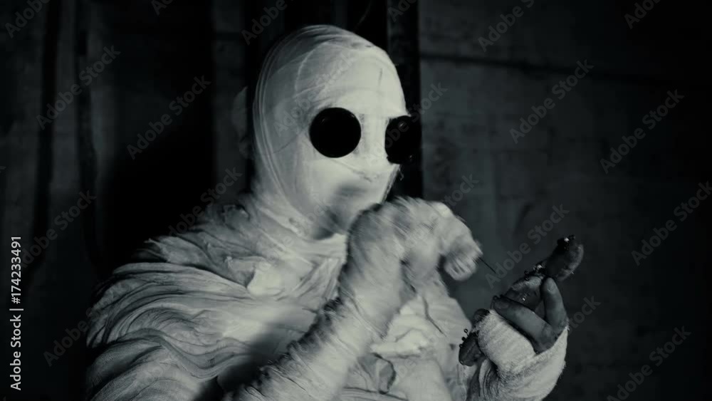 people being in bandages in a dark, abandoned building holding a voodoo doll for ritual people being in bandages in a dark, abandoned building holding a voodoo doll for ritual