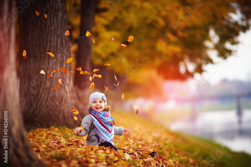 Wallpaper Mural adorable happy baby girl throwing the fallen leaves up, playing in the autumn park Torontodigital.ca