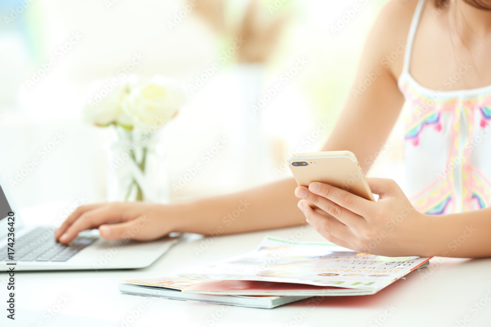 Female blogger with laptop and cell phone at table Female blogger with laptop and cell phone at table