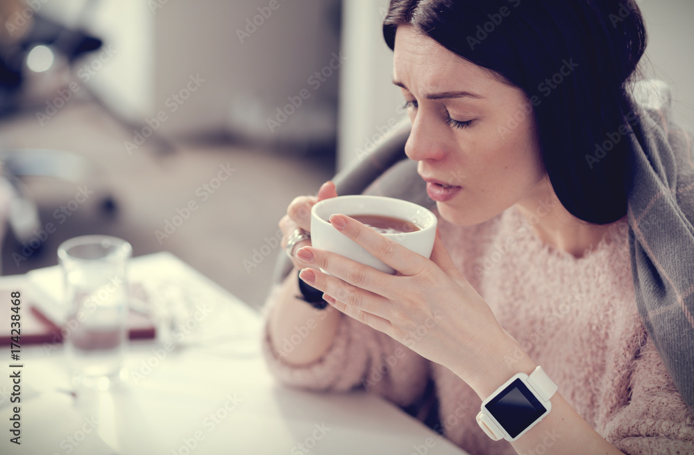 Nice ill woman enjoying hot tea