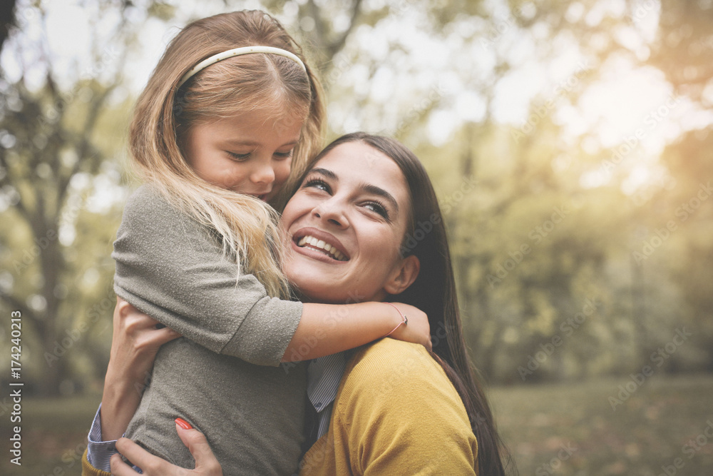 Mother and daughter on meadow. Mother and daughter playing with hands. Mother and daughter on meadow. Mother and daughter playing with hands.