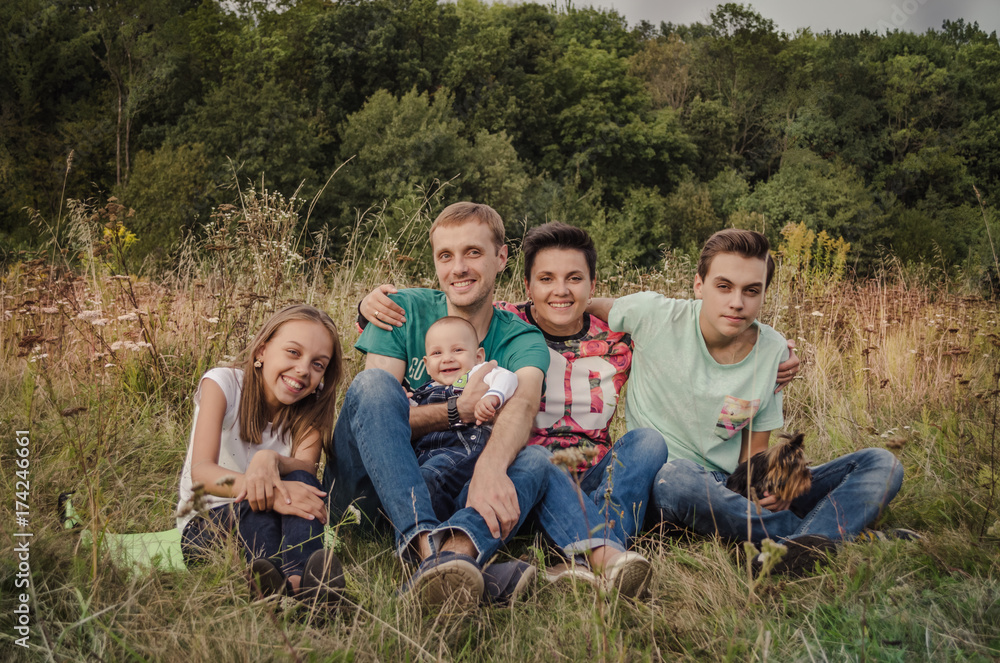 Happy young family spending time together outside in green nature.